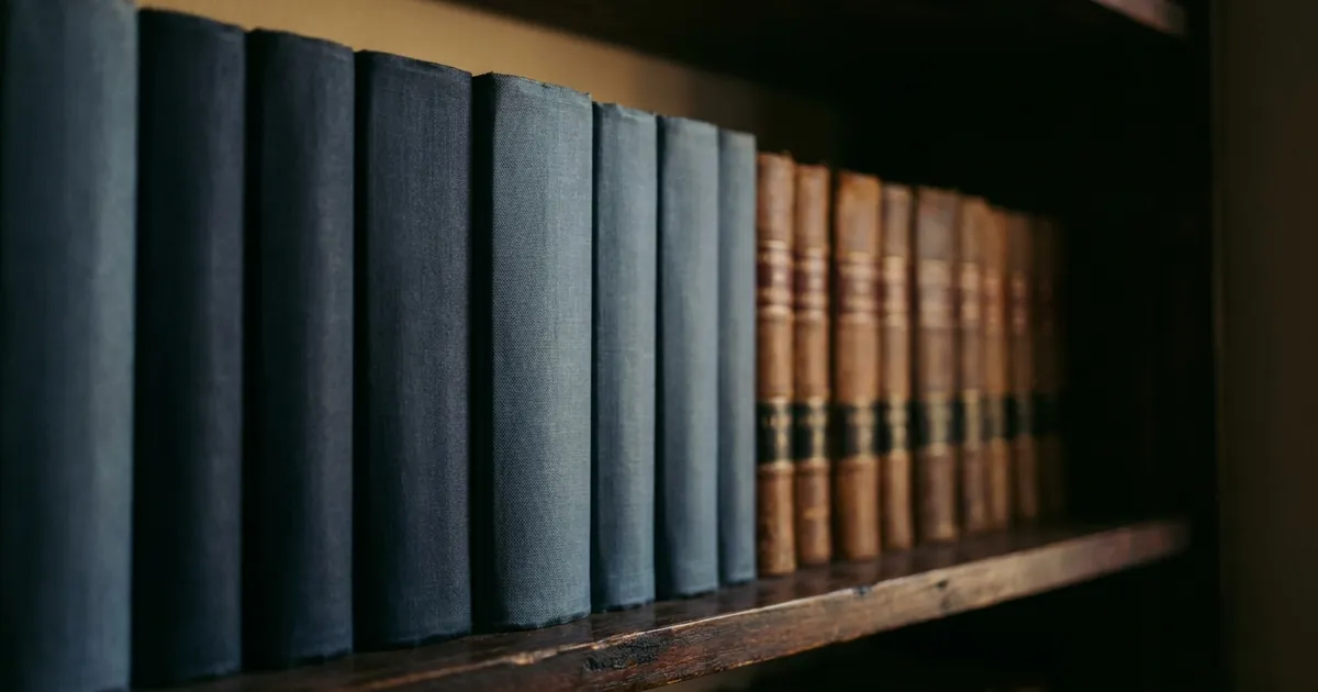 A row of bound legal volumes on a dark wooden shelf