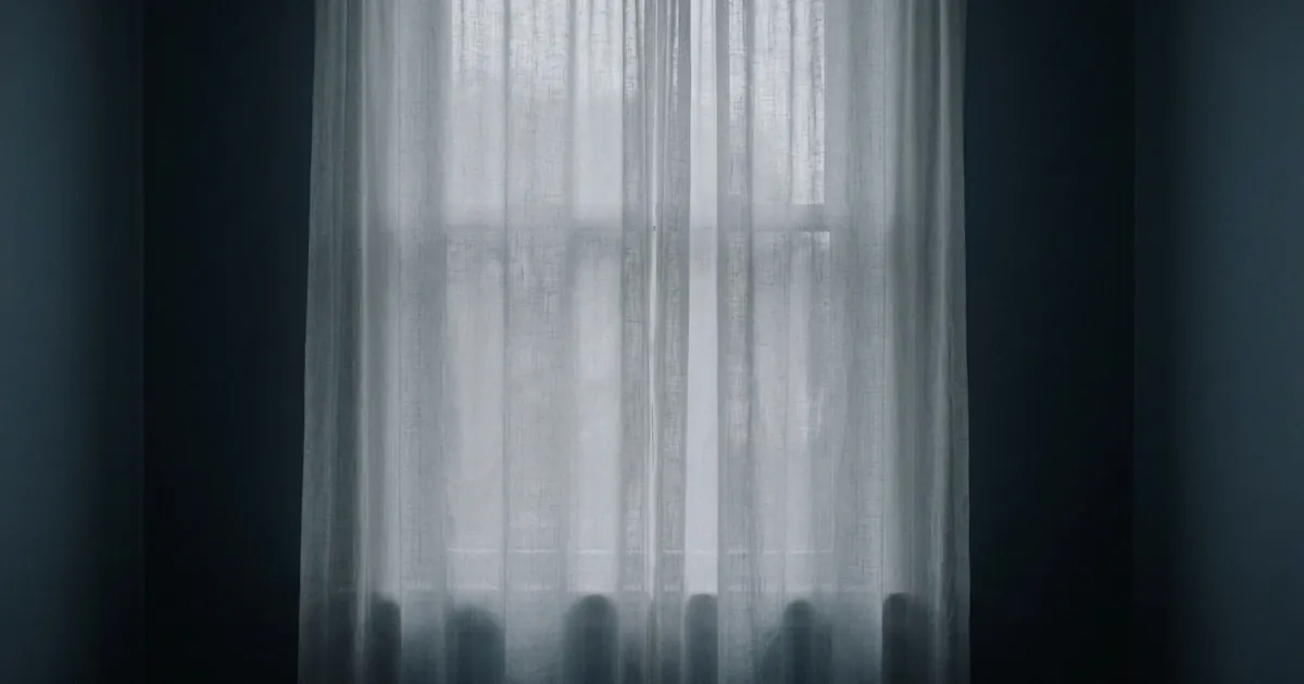 Soft daylight diffusing through a plain sheer curtain