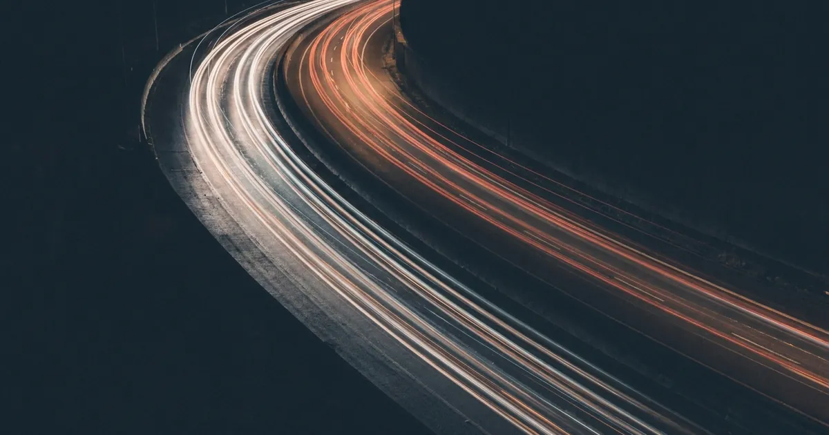 Long-exposure red and white light trails along a night highway